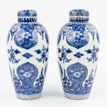 A pair of Chinese vases with lids, with a blue-white flower decor. (24 x 11 cm)