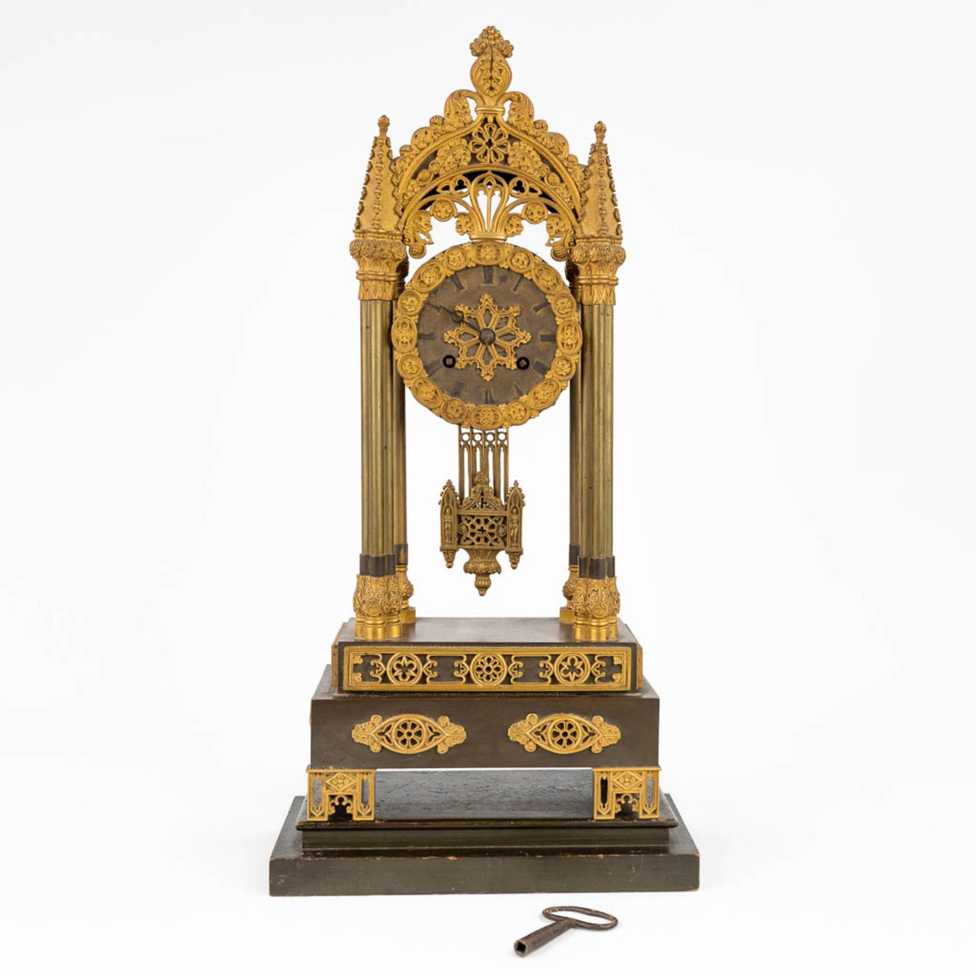 A table column clock made of gilt bronze in a gothic revival style. (11 x 19,5 x 43cm)