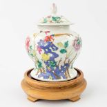 A Chinese jar with a lid made of porcelain with a flower decor and bird/phoenix. Marked Shende Tang