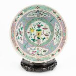 A Chinese Famille rose bowl, made of porcelain and decorated with antiquities and flowers (11,5 x 34