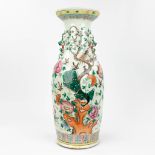 A Chinese vase made of porcelain, decorated with peacocks and birds. (61,5 x 24 cm)