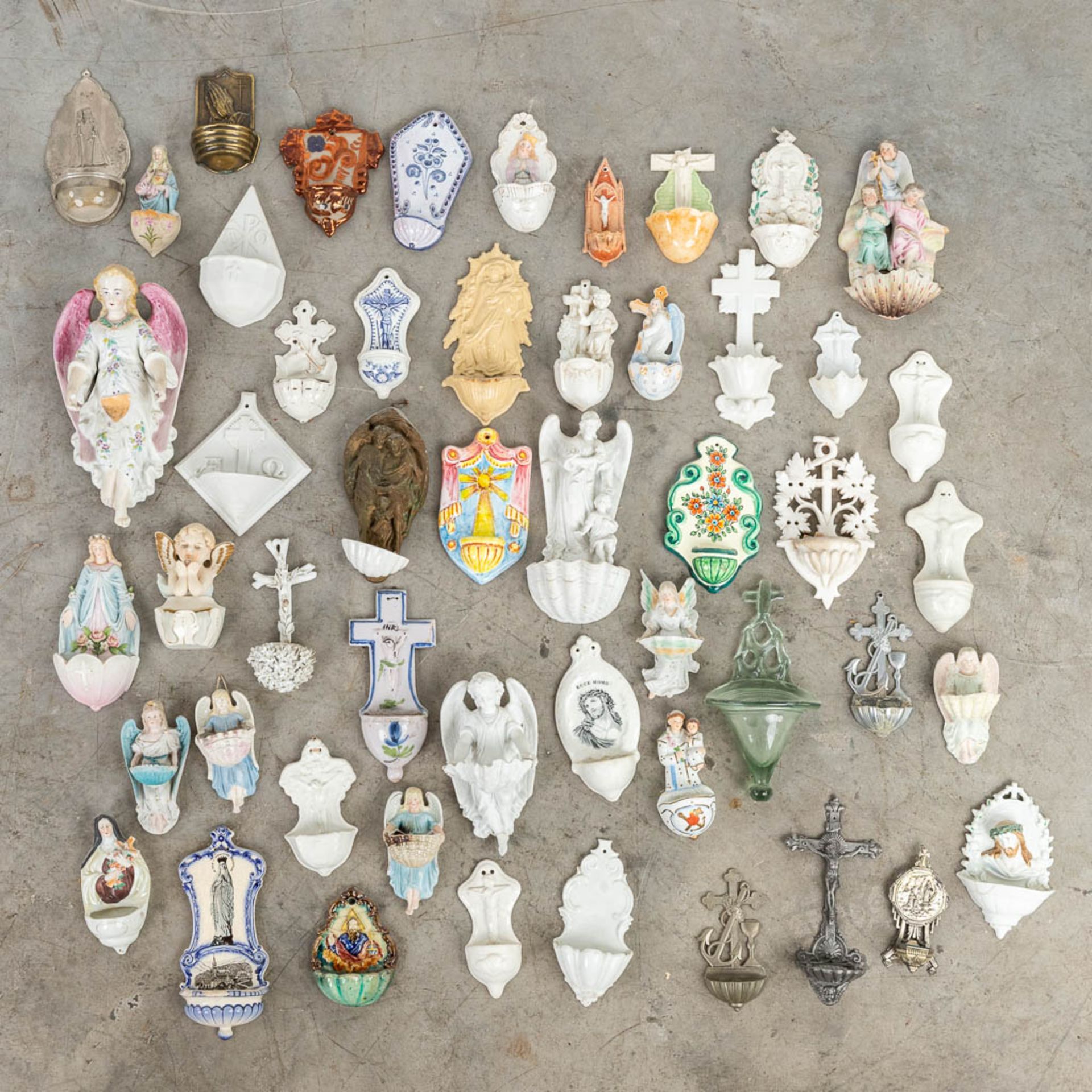 A collection of holy water fonts, made of ceramics, porcelain and wood. 20th C. (15 x 30cm)