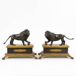 A pair of lions on a stand, made of patinated and gilt bronze in empire style. (17,5 x 32 x 26cm)