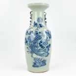 A Chinese vase made of porcelain, with a blue-white decor of a large peacock. (60 x 24 cm)