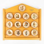 Hummel, a collection of 13 plates in a wood display case. (8,3cm)