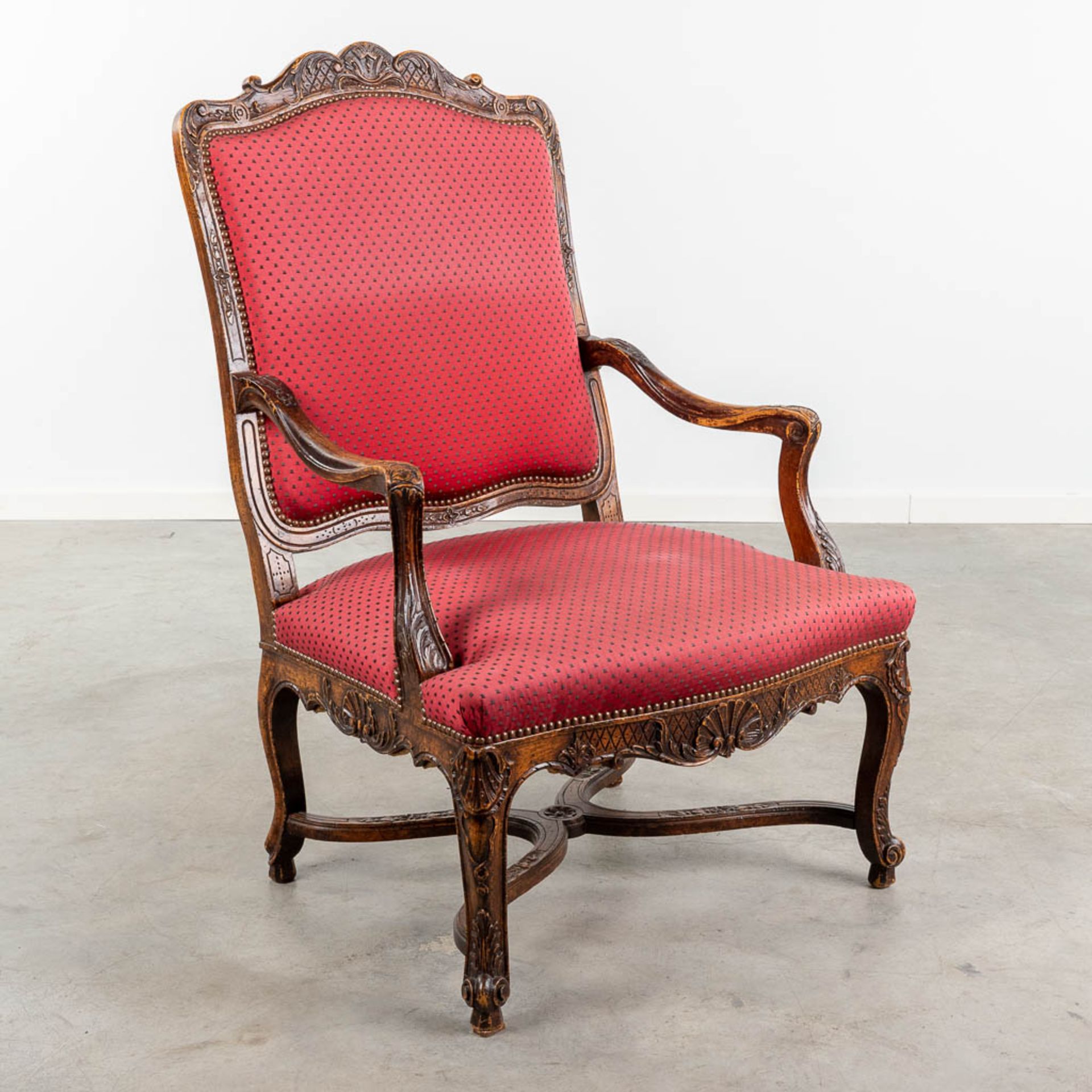 An armchair finished with red fabric and wood sculptures in Louis XV style. (L:73 x W:72 x H:108 cm