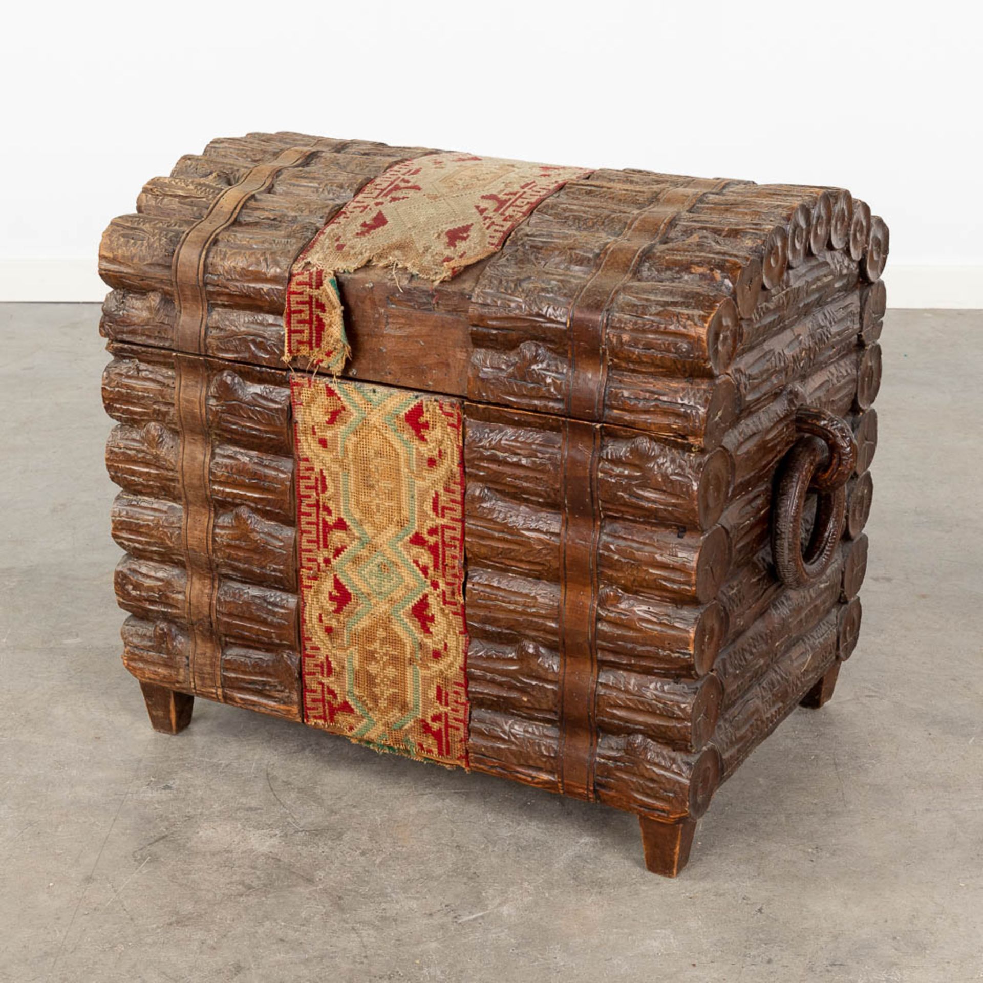 A decorative chest with wood sculptures finished with fabric. (L:39 x W:64 x H:51 cm)