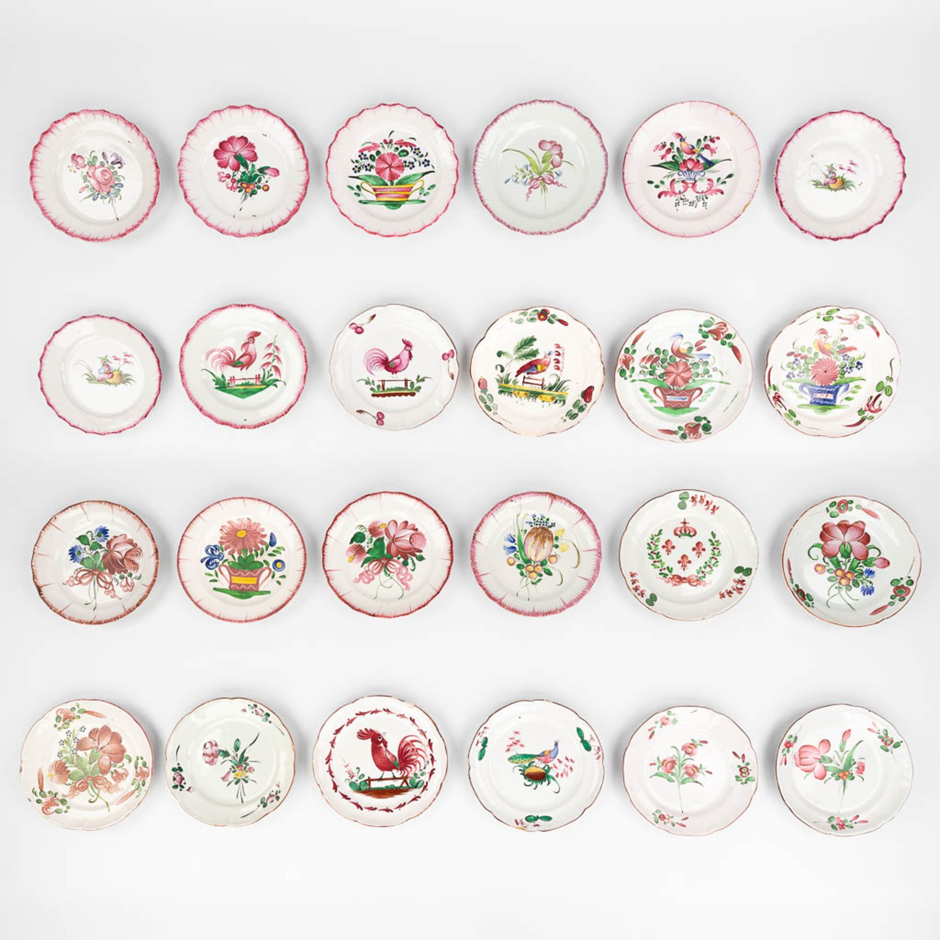 Faience De l'Est, a large collection of 24 plates with hand-painted flower decor. (D:22,5 cm)