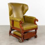 An antique wheelchair, made of wood upholstered with skai. (L:95 x W:80 x H:114 cm)