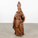 An antique wood sculpture of a saint with a mitre and book. Circa 1900. (L:21 x W:33 x H:97 cm)