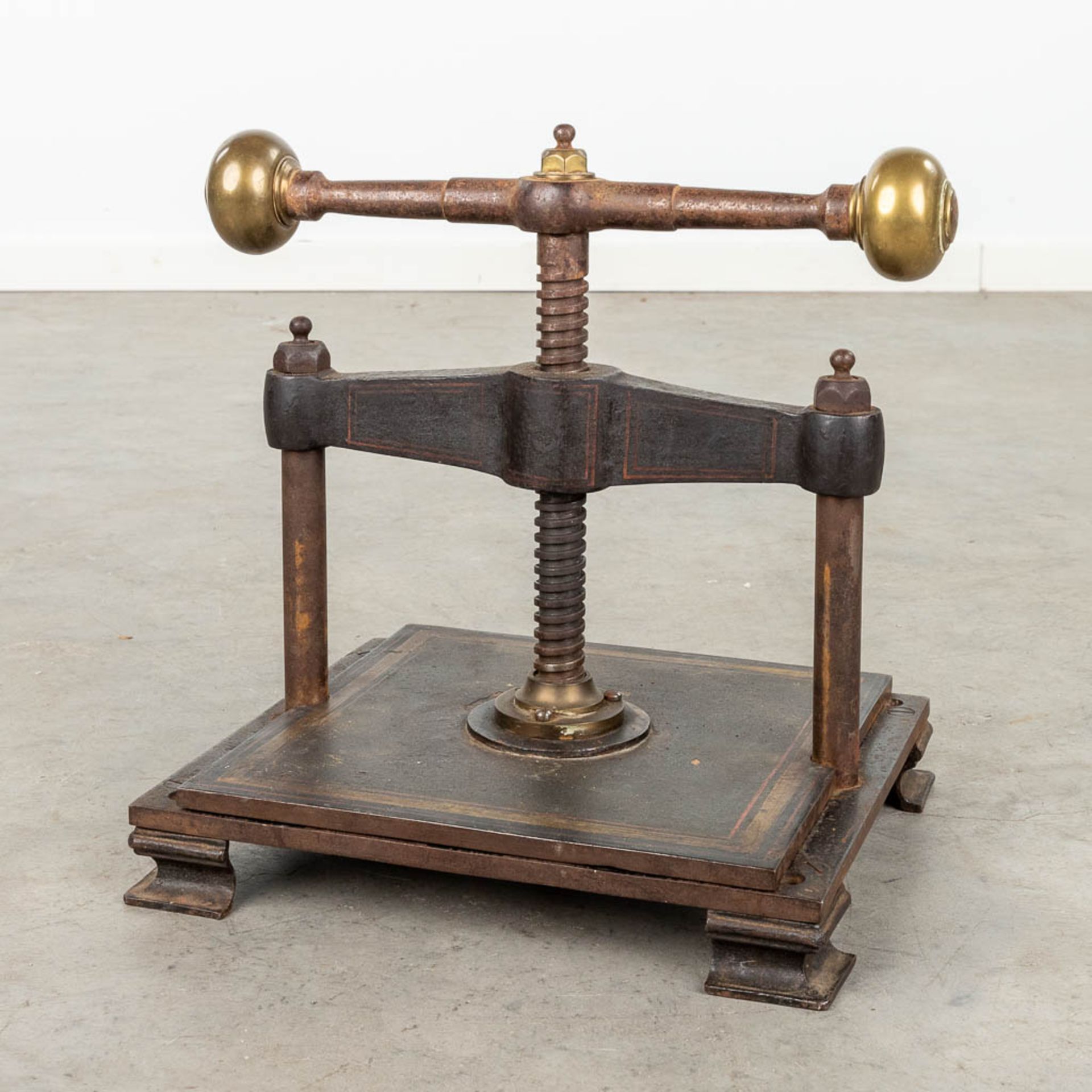 An antique book press, made of metal. (L:30 x W:38 x H:36 cm)