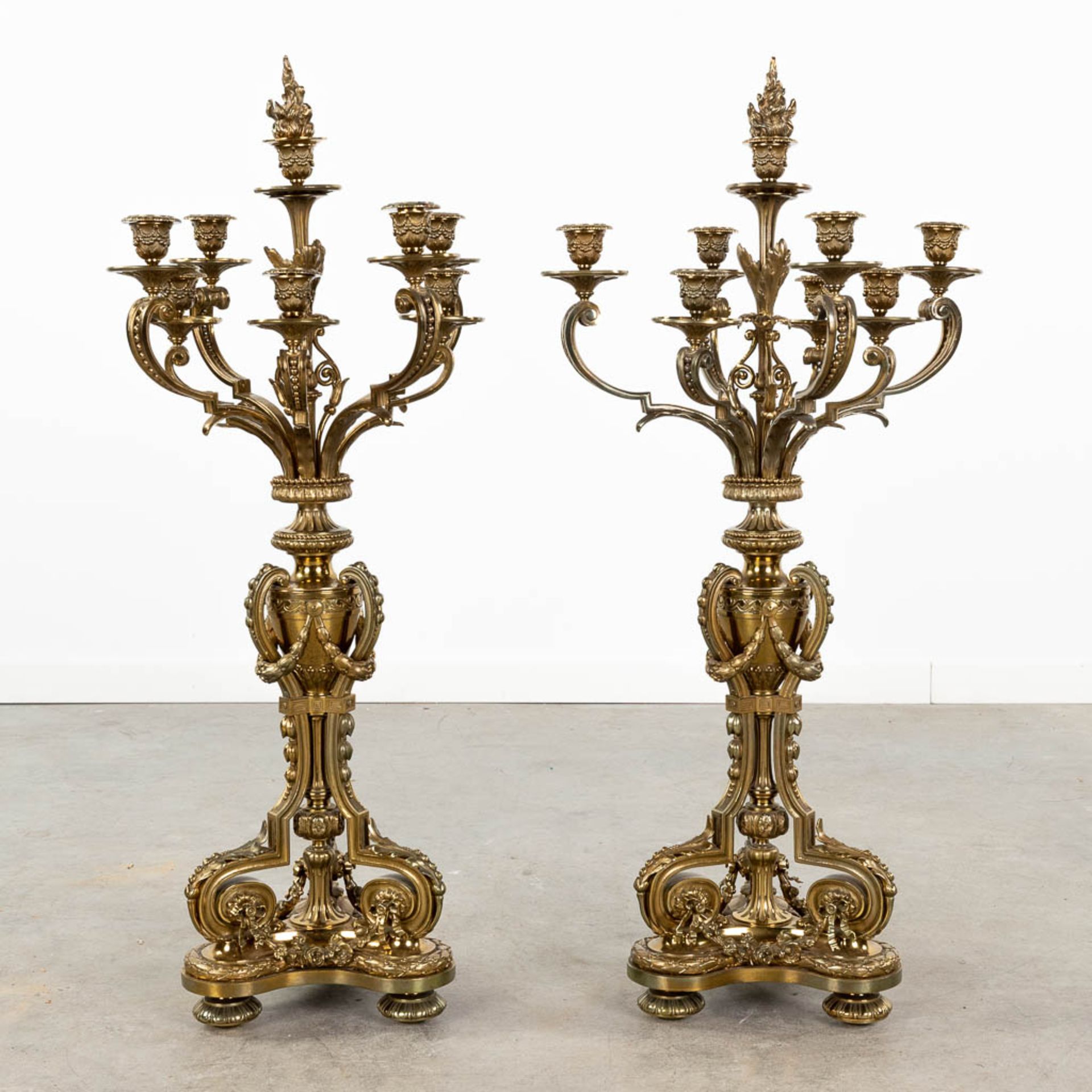 A pair of large neoclassical candelabra made of polished bronze. (L:30 x W:30 x H:90 x D:42,5 cm)