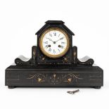A mantle clock made of black marble and finished with yellow accents. (W:37 x H:26 cm)