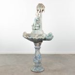 A fountain, made of glazed ceramics and finished with angels, a figurine and palm tree. Circa 1960.