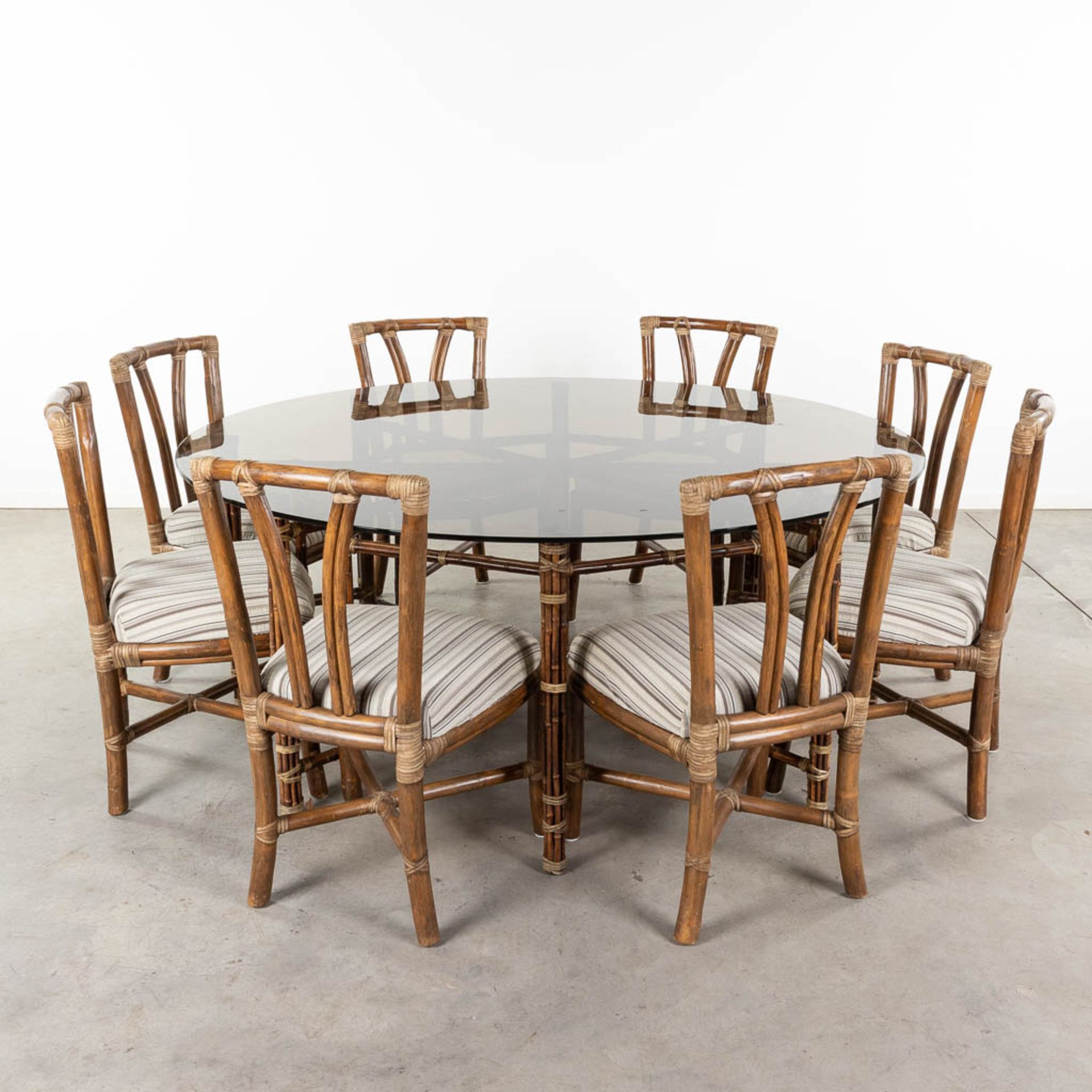 McGuire Furniture company, a large round dining room table with 8 chairs. (H:73 x D:180 cm)