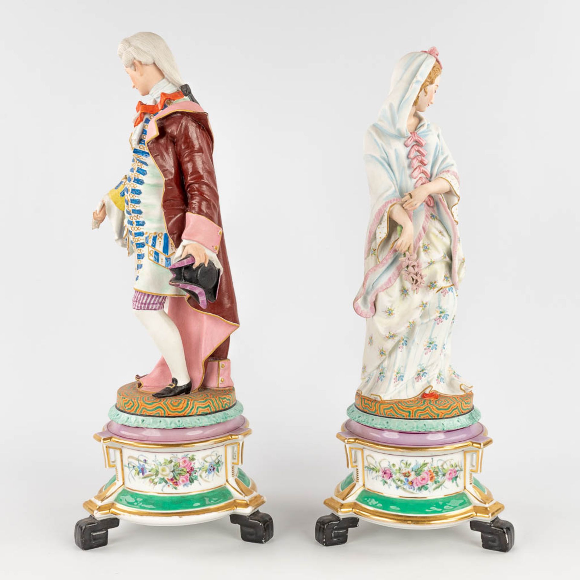 A pair of antique bisque figurines, standing on a glazed porcelain base. (L: 18 x W: 18 x H: 49 cm) - Image 6 of 24