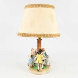 Dresden, a porcelain table lamp decorated with dancing children. (H: 47 cm)
