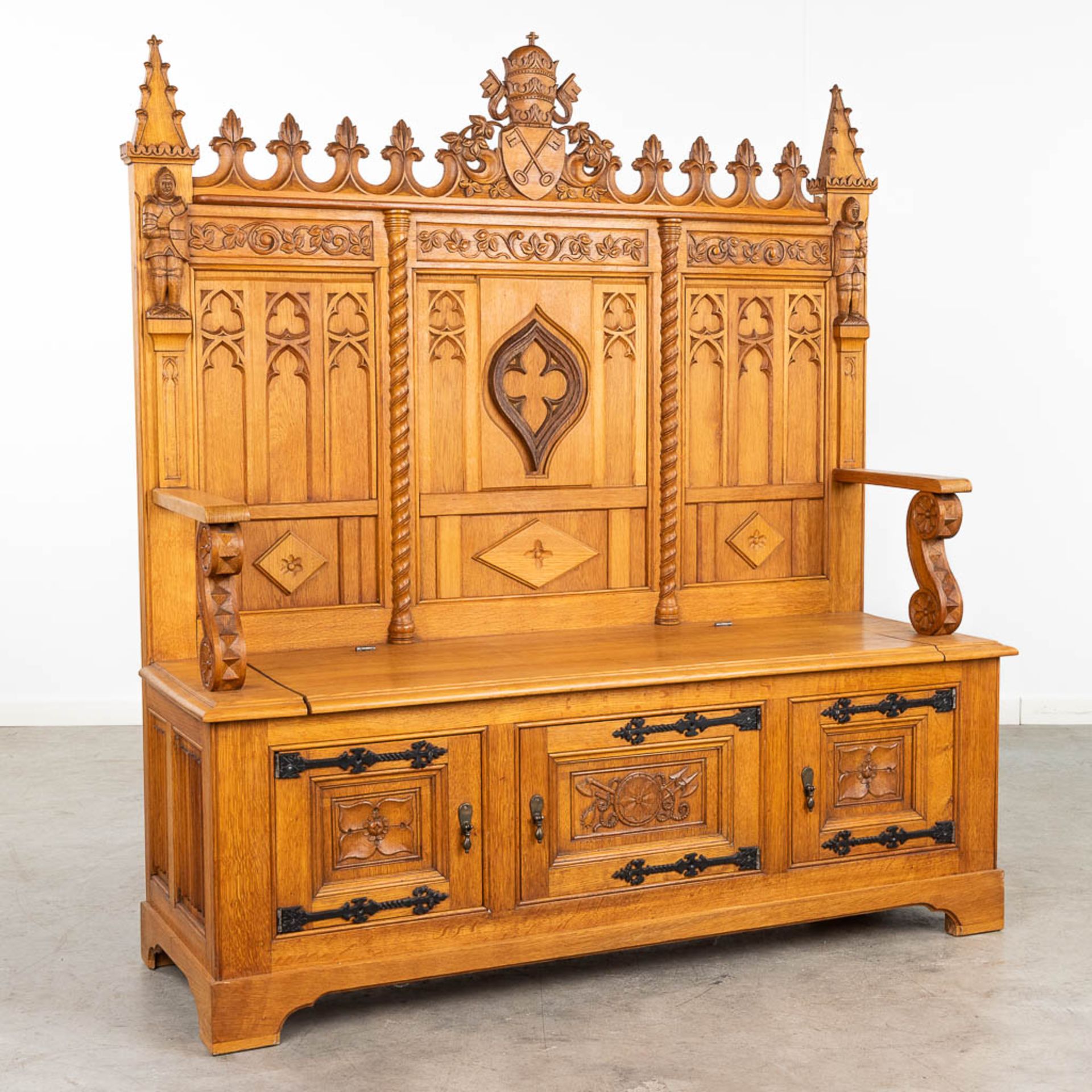 A large and antique bench finished with wood sculptured in a Gothic Revival style. 20th century. (L: