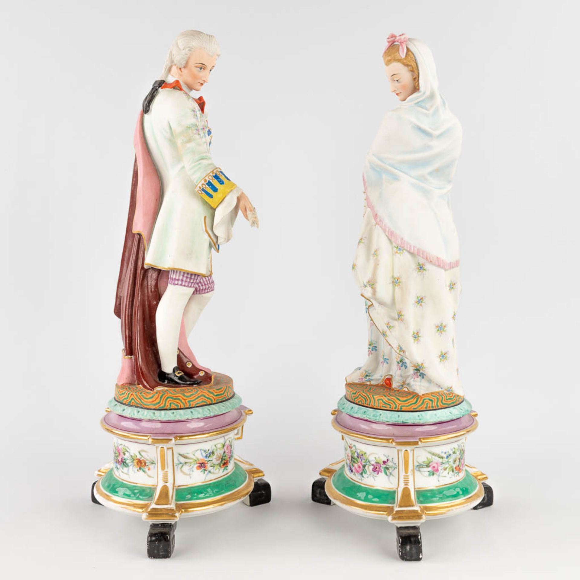 A pair of antique bisque figurines, standing on a glazed porcelain base. (L: 18 x W: 18 x H: 49 cm) - Image 3 of 24