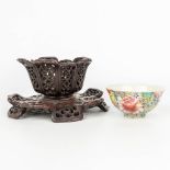 A Chinese porcelain bowl with a floral decor in a sculptured wood lotus flower stand. Marked Qianlon