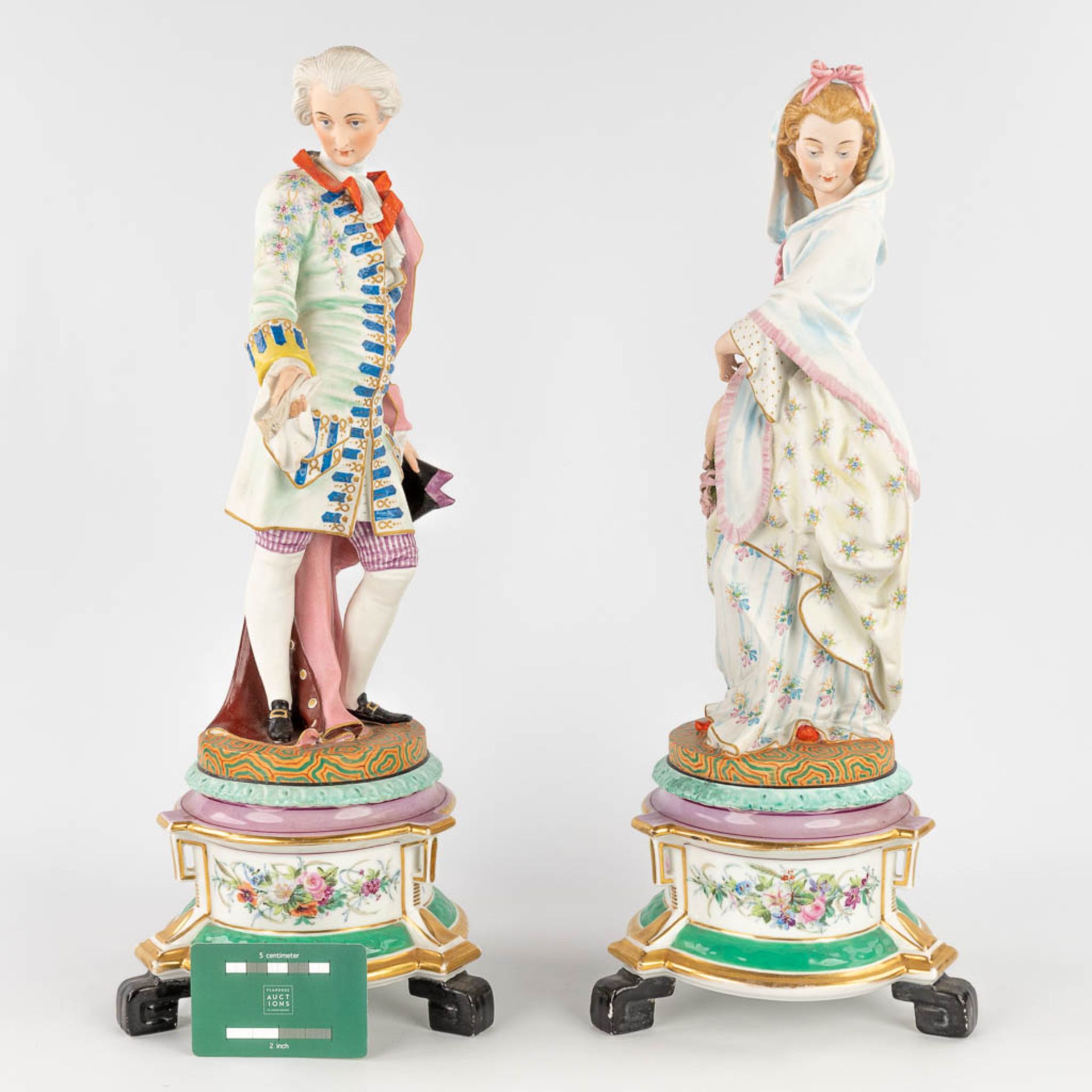 A pair of antique bisque figurines, standing on a glazed porcelain base. (L: 18 x W: 18 x H: 49 cm) - Image 2 of 24