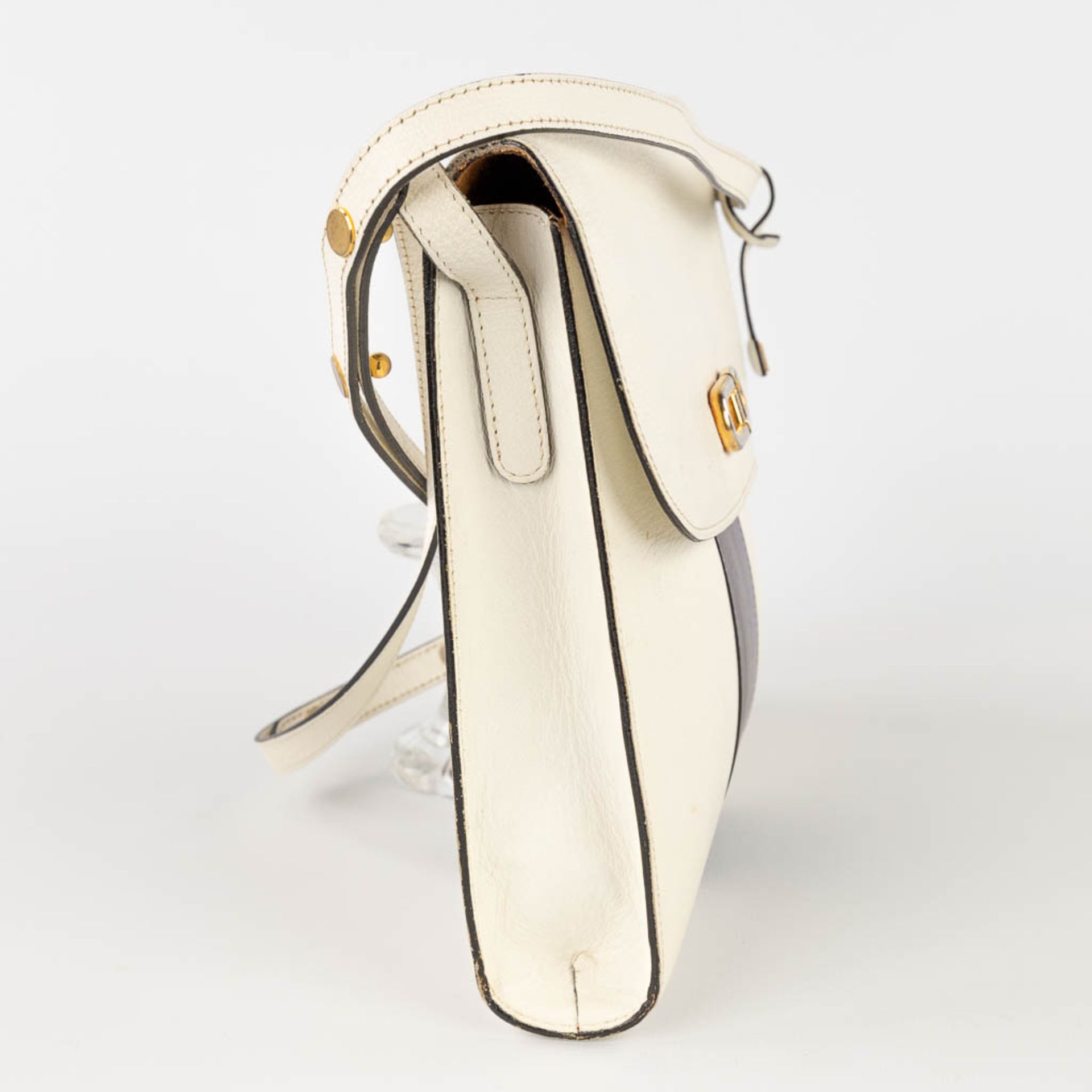 Delvaux, a handbag made of white leather decorated with colored stripes, and gold-plated hardware. ( - Image 5 of 18