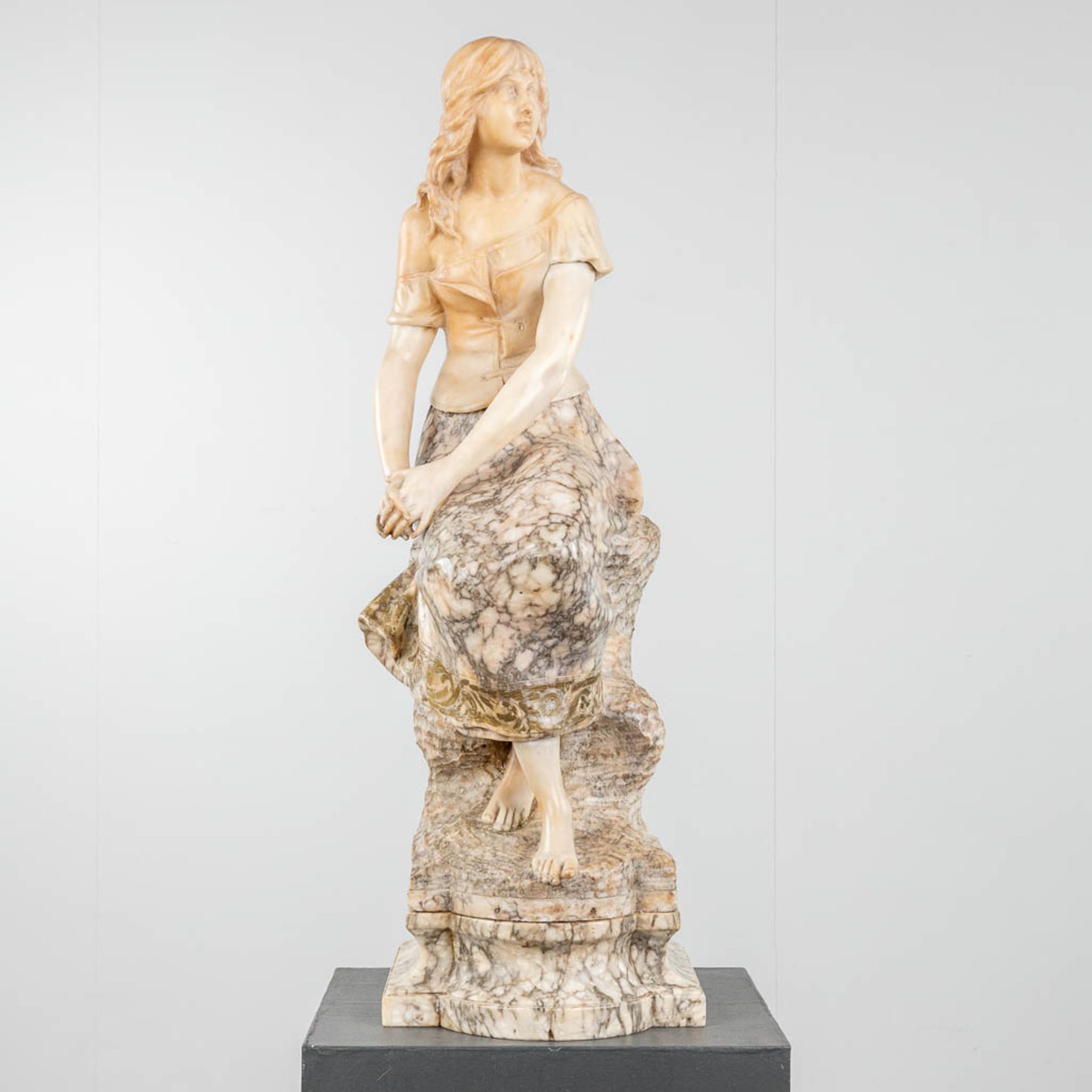 An exceptional statue of a lady, seated on a rock. Sculptured alabaster. 19th century. (L: 37 x W: 3
