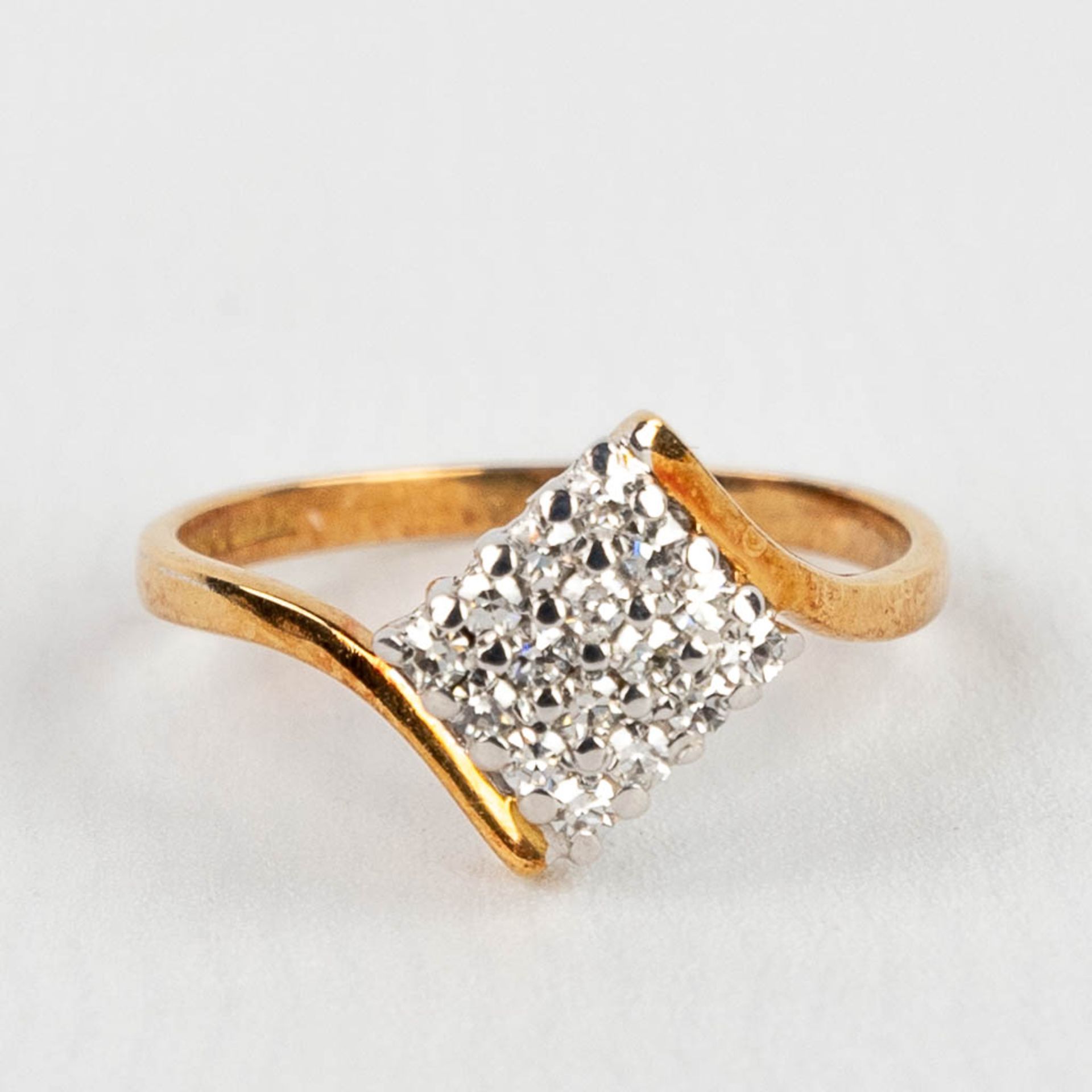 A yellow and white gold ring finished with 9 brilliants. 2,14g. size: 51