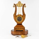 An antique Lyre mantle clock, Marquetry inlayed wood mounted with bronze in empire style. 19th C. (L