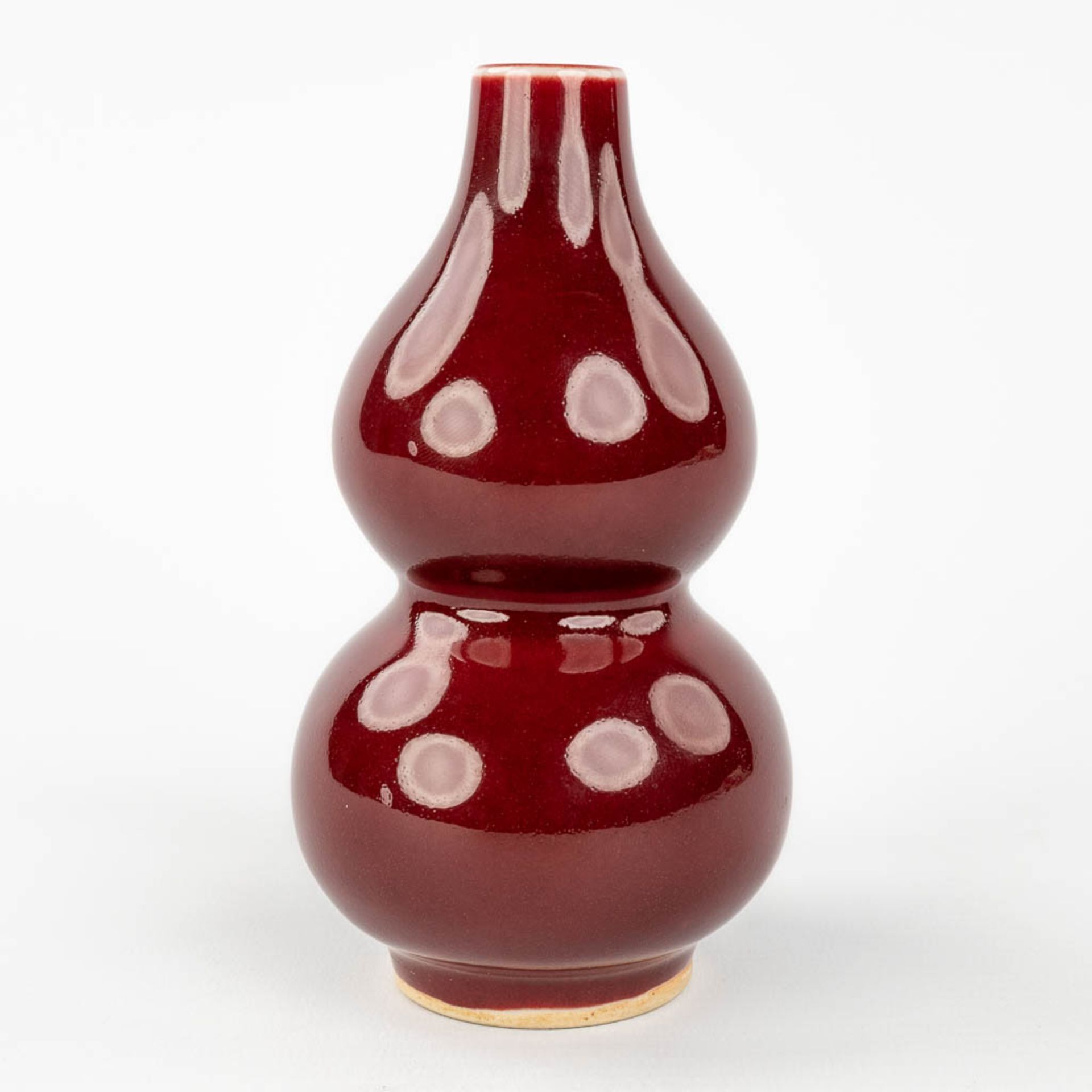 A Chinese double gourd vase, Sang De Boeuf glaze, 19th/20th century. (H: 13 x D: 7,5 cm) - Image 5 of 8