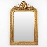 A mirror in a gilt frame, decorated with a musical putto. (W: 69 x H: 108 cm)