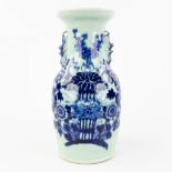 A Chinese vase with blue-white flower decor and celadon glaze. 19th/20th C. (H: 42 x D: 21 cm)