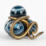 A paperweight, made of 4 glass balls with a brass snake. 20th century. (L: 6,5 x W: 6,5 x H: 5,5 cm)