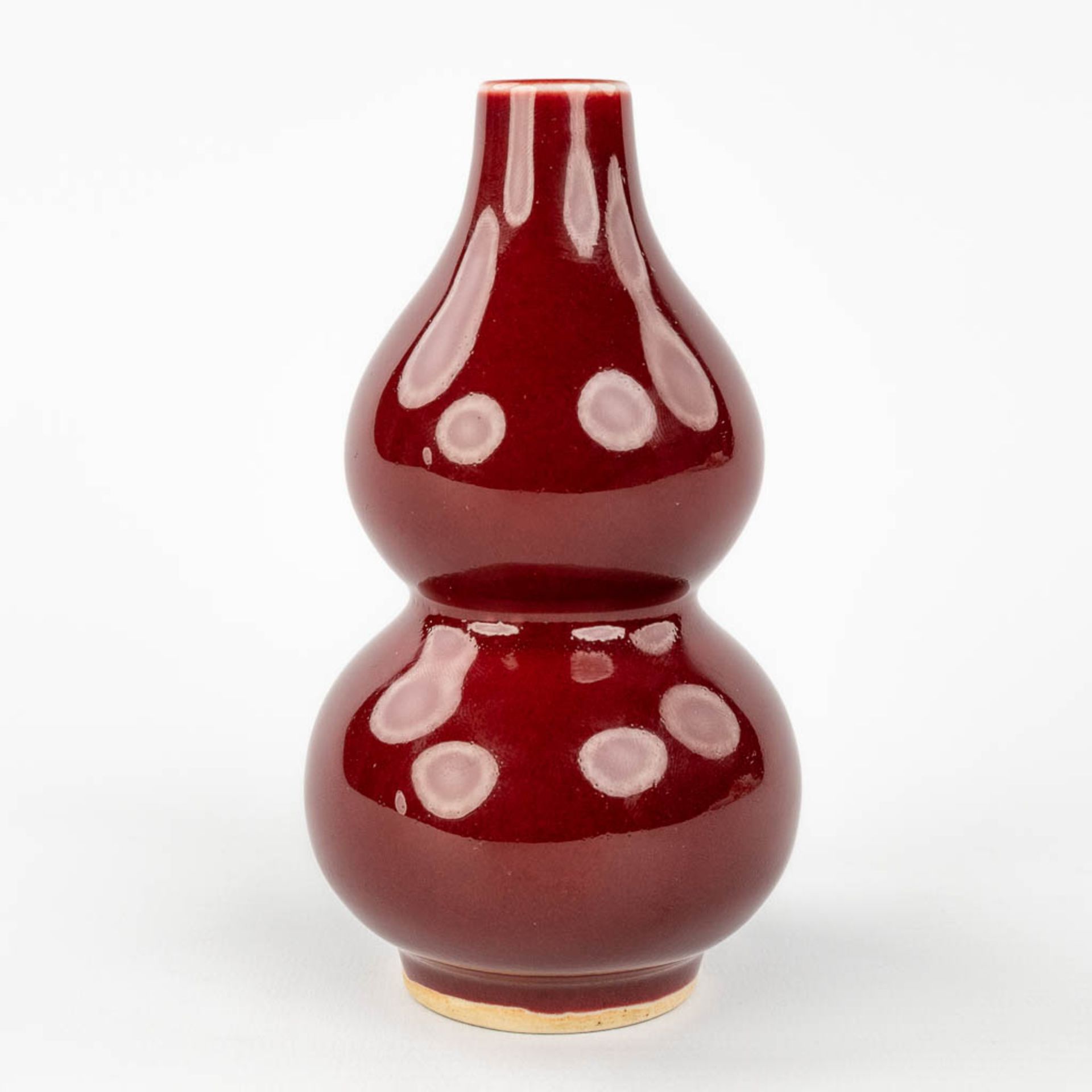 A Chinese double gourd vase, Sang De Boeuf glaze, 19th/20th century. (H: 13 x D: 7,5 cm) - Image 3 of 8