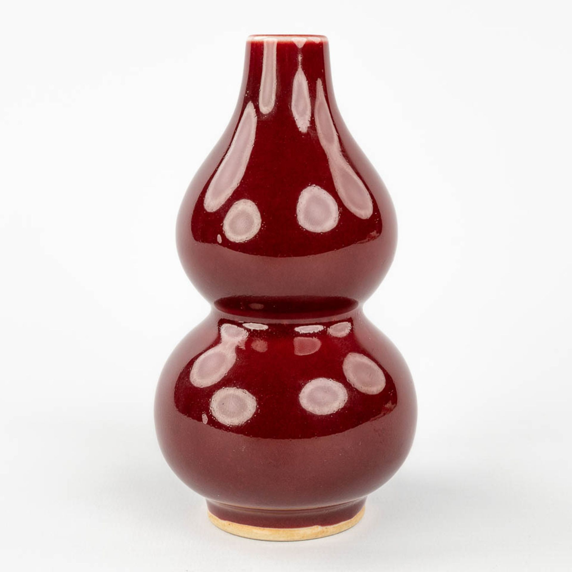 A Chinese double gourd vase, Sang De Boeuf glaze, 19th/20th century. (H: 13 x D: 7,5 cm) - Image 4 of 8