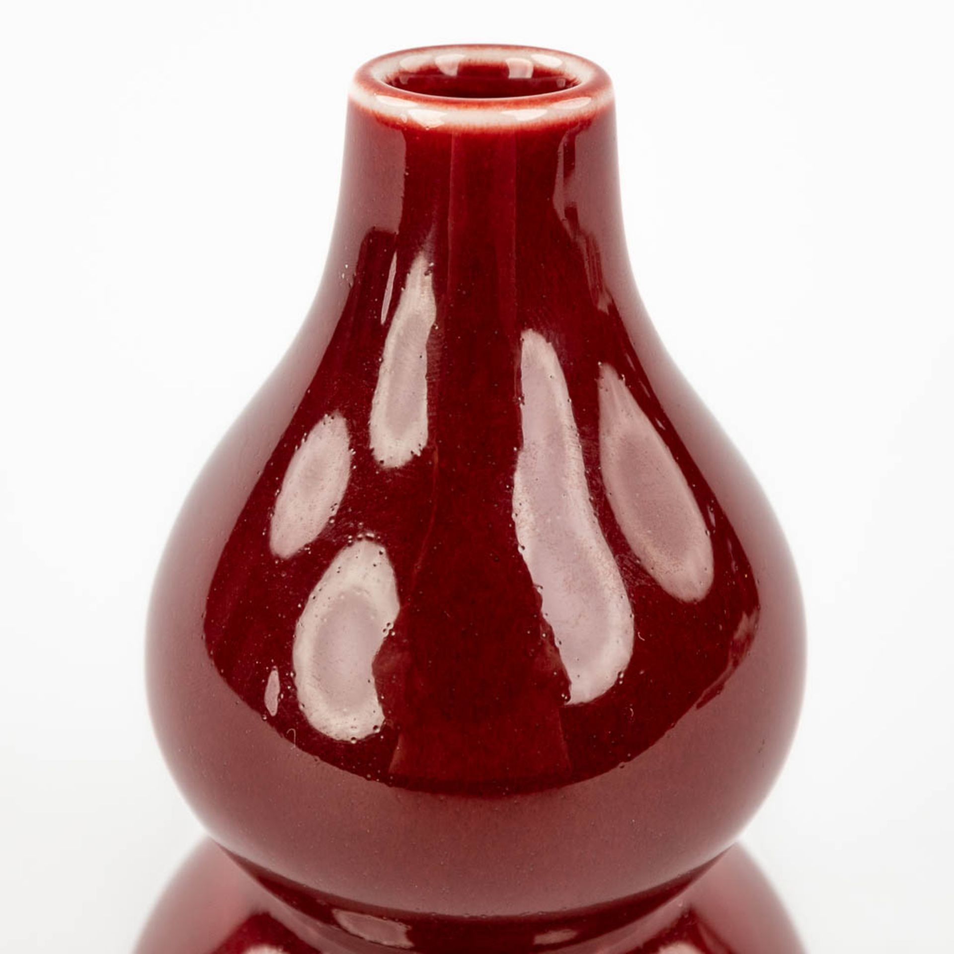 A Chinese double gourd vase, Sang De Boeuf glaze, 19th/20th century. (H: 13 x D: 7,5 cm) - Image 8 of 8