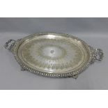 A large silver plated tray with a family crest to centre and engraved pattern, handles to side and