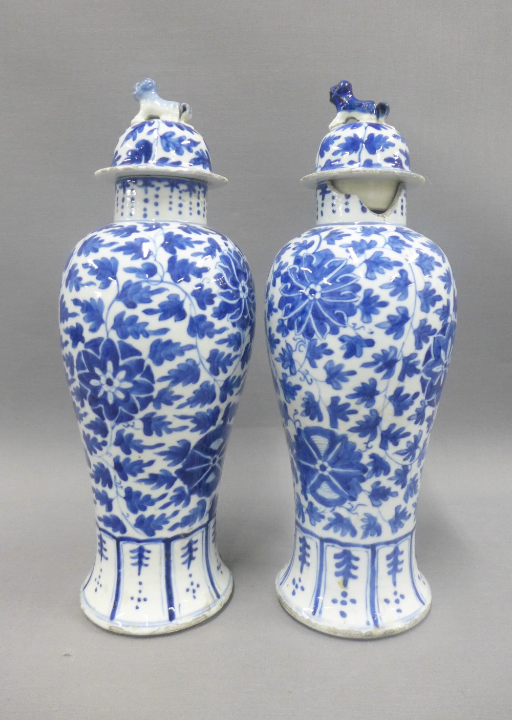 Pair of Chinese blue and white high shouldered baluster vases, covers with dog finials, painted