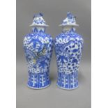 Pair of Chinese blue and white high shouldered baluster vases, covers with dog finials, painted