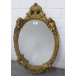 Faux giltwood cherub wall mirror with an oval plate, size overall 65 x 42cm