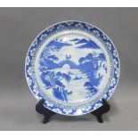 Chinese blue and white porcelain plate, river and landscape scene within a border of blossom, 24cm