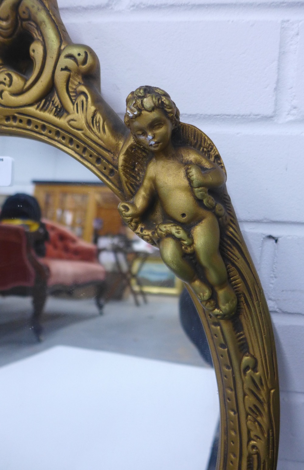 Faux giltwood cherub wall mirror with an oval plate, size overall 65 x 42cm - Image 3 of 3
