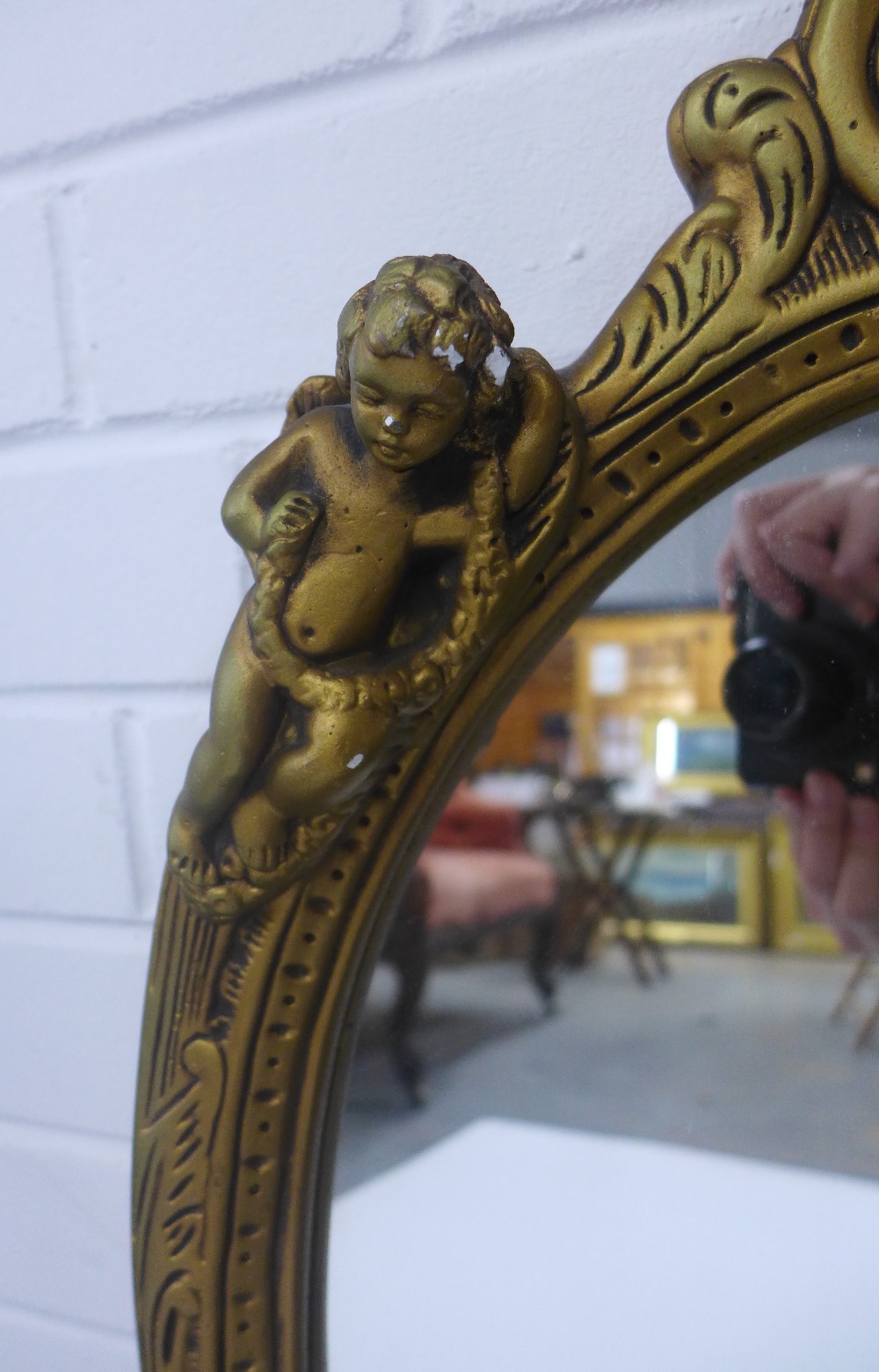 Faux giltwood cherub wall mirror with an oval plate, size overall 65 x 42cm - Image 2 of 3