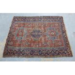 North West Persian rug, rust field with three blue medallions and multiple borders, 194 x 148cm