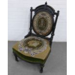 Victorian ebonised and parcel gilt nursing chair with a curved top rial centred by an urn finial,