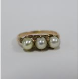 Three stone grey pearl ring, claw set on an unmarked gold band