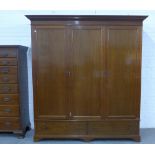 Mahogany triple wardrobe, the interior with hanging space and pull out slides, with two long drawers
