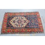 Persian rug, blue field with ivory panel containing a rhomboid medallion, with geometric and