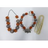 Two Indian white metal and amber coloured bead necklaces and a carved bone necklace, (3)