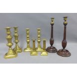 Pair of wooden candlesticks with brass sconces and a three pairs of brass candlesticks, tallest